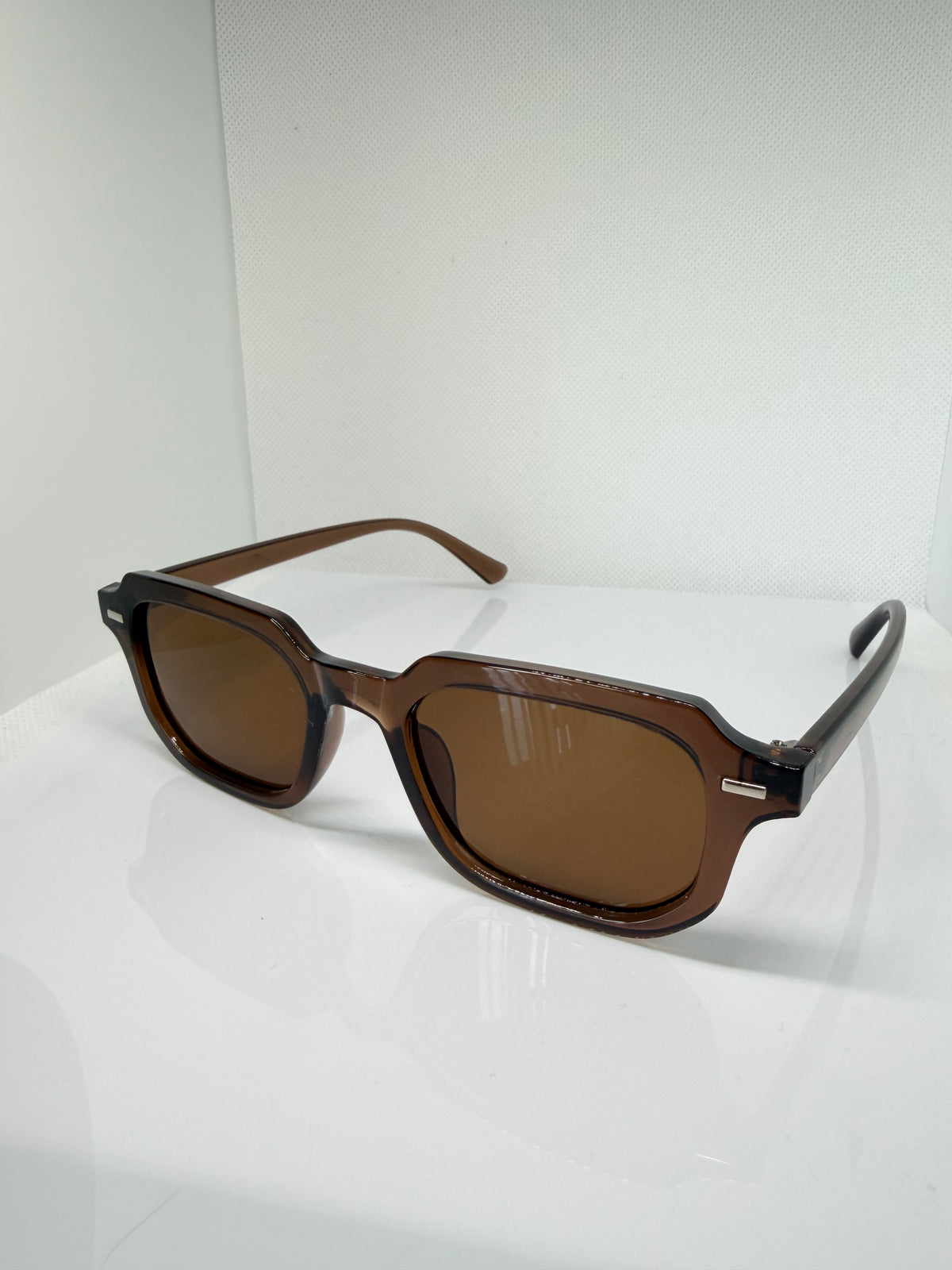 Close-up of Mocha brown rectangle sunglasses showing the frame and tinted lenses