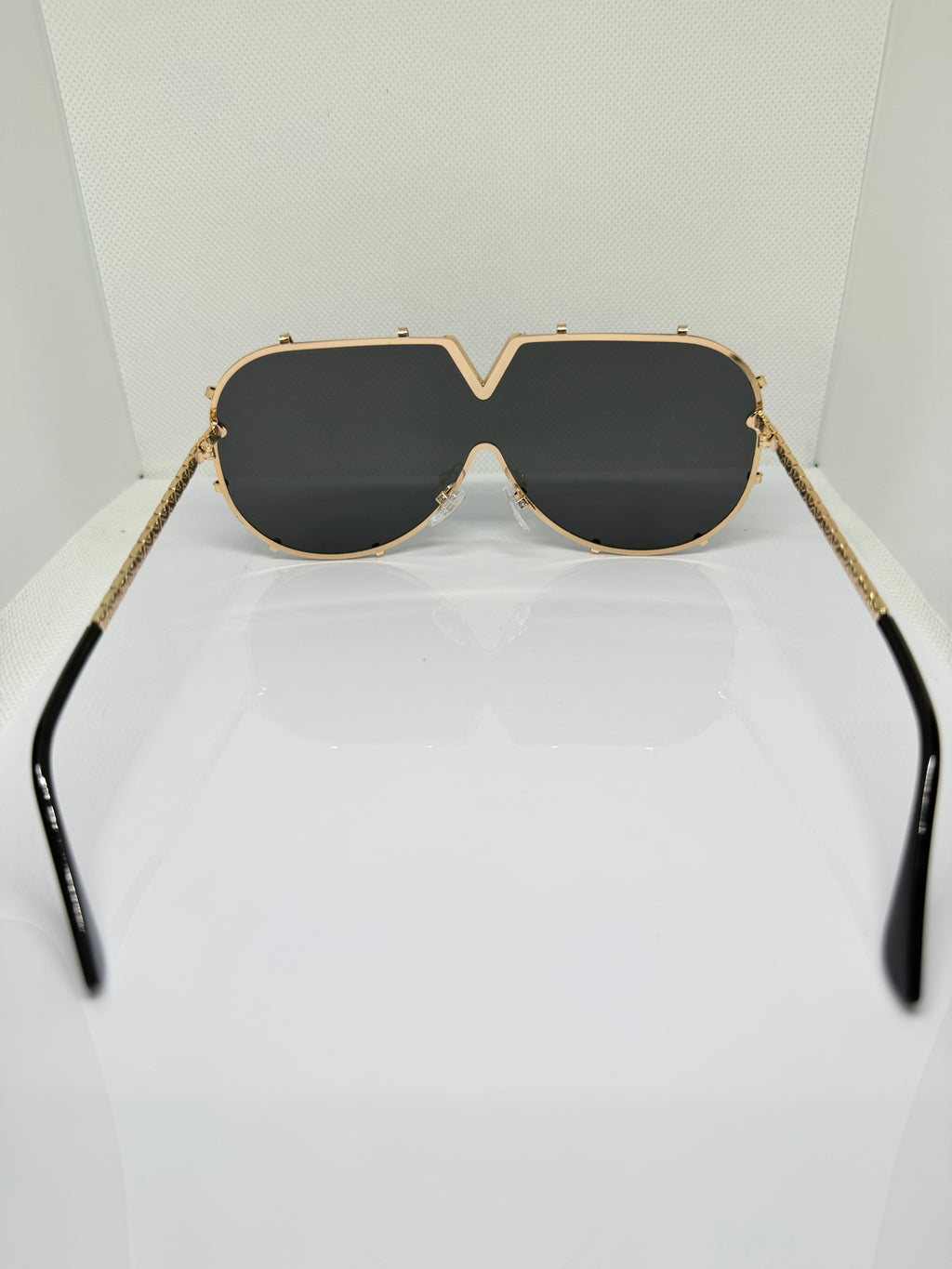 Close-up of Valencia sunglasses showing the gold V-detail