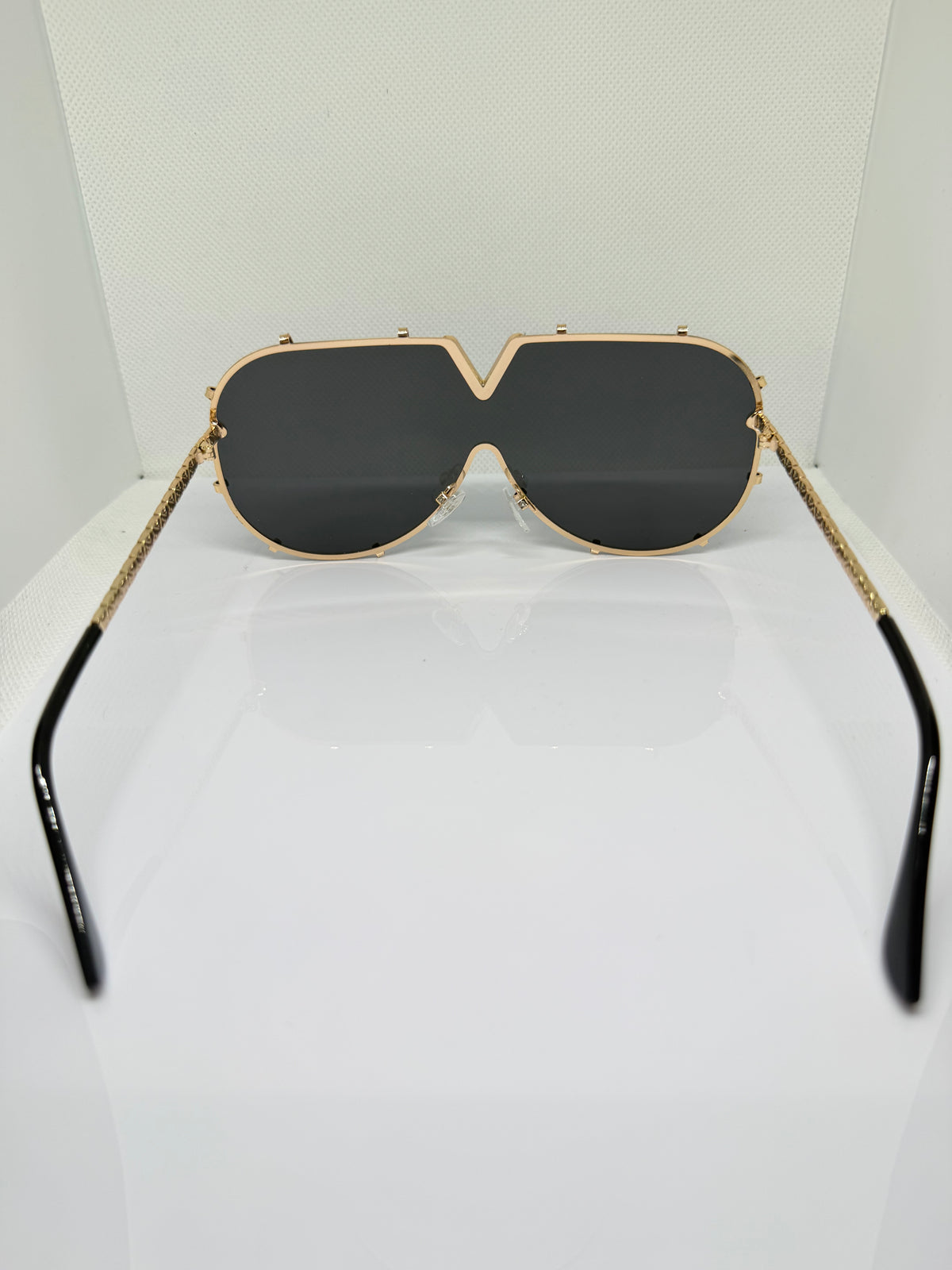 Close-up of Valencia sunglasses showing the gold V-detail