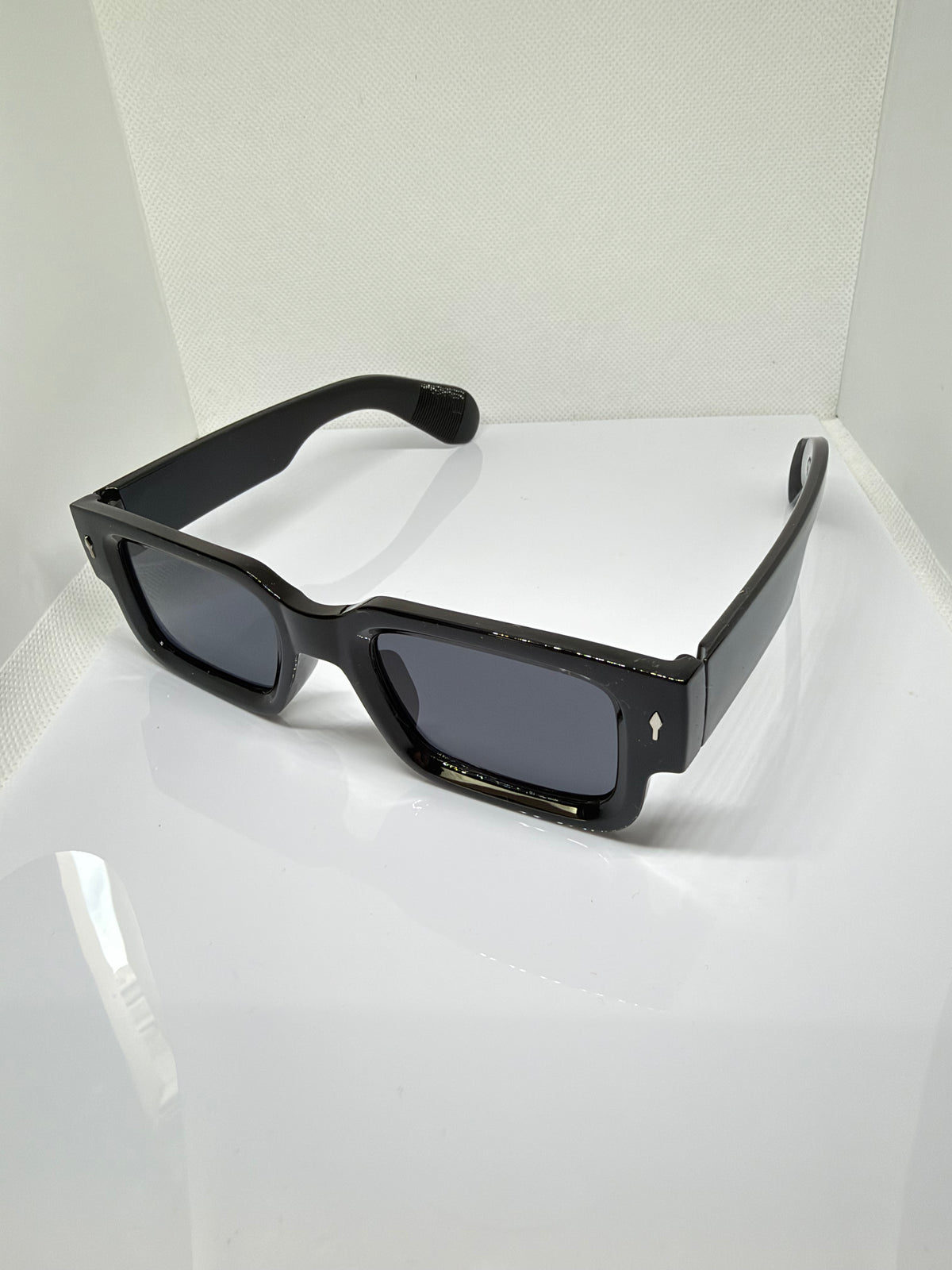Obsidian sunglasses featuring a bold rectangular frame and thick black temples