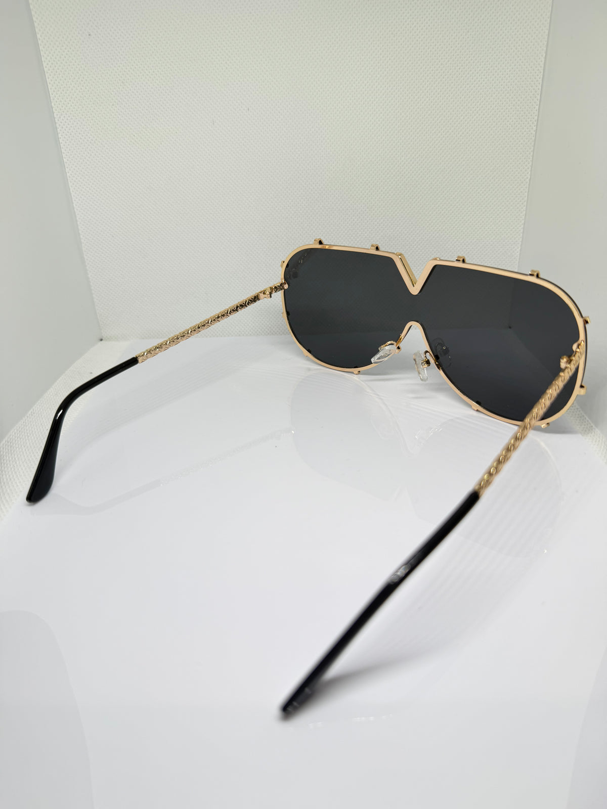 Valencia black aviator sunglasses with gold V-detail across the frame
